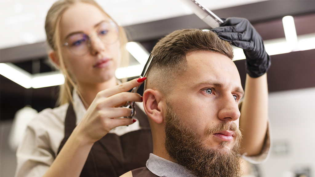 A man getting a haircut in a modern barber shop.