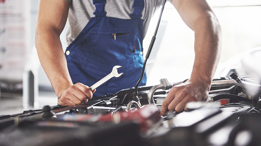 A mechanic working on a car in a garage.